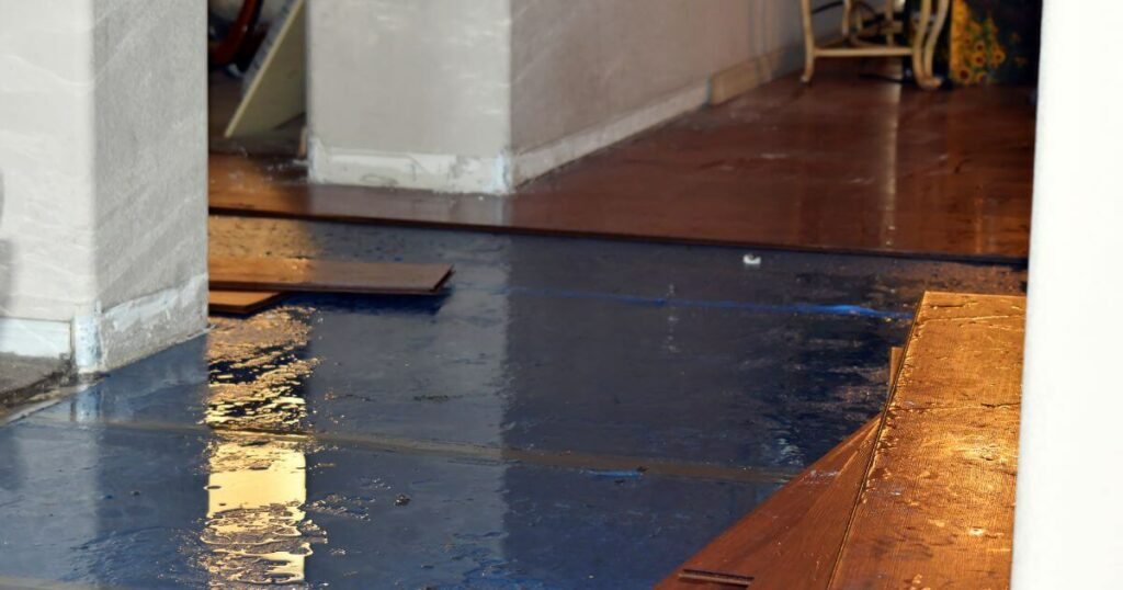 A home with water damage affecting hardwood floors, highlighting the need for professional water damage restoration services.